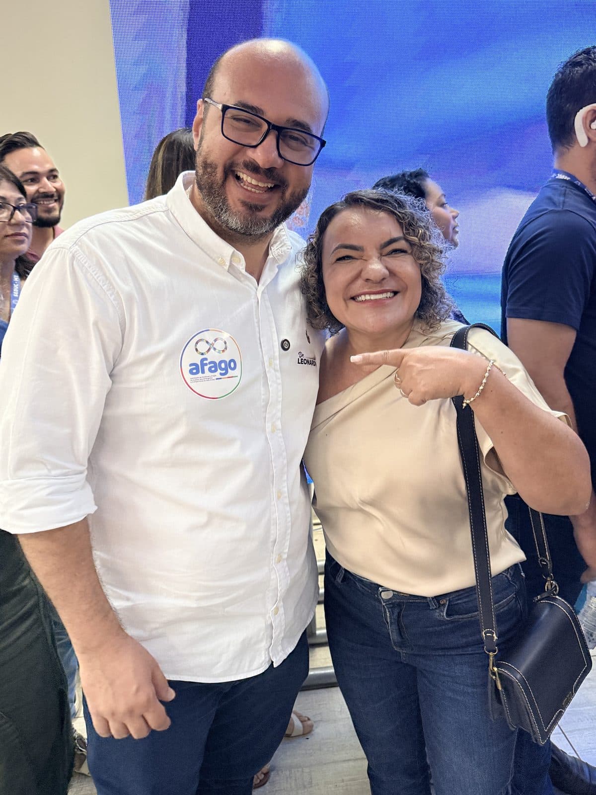 Apoiadora sorridente aponta para o Dr. Leonardo durante encontro do movimento
