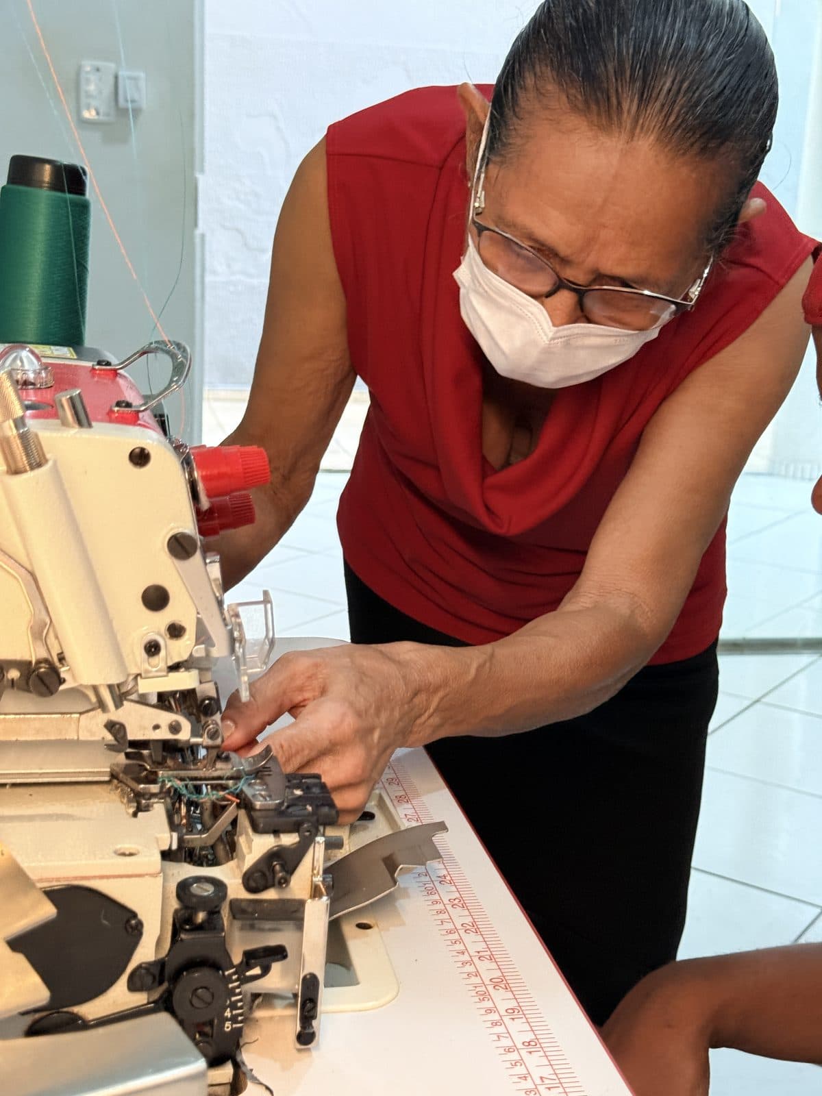 Aluna do projeto de corte e costura trabalha na máquina de costura