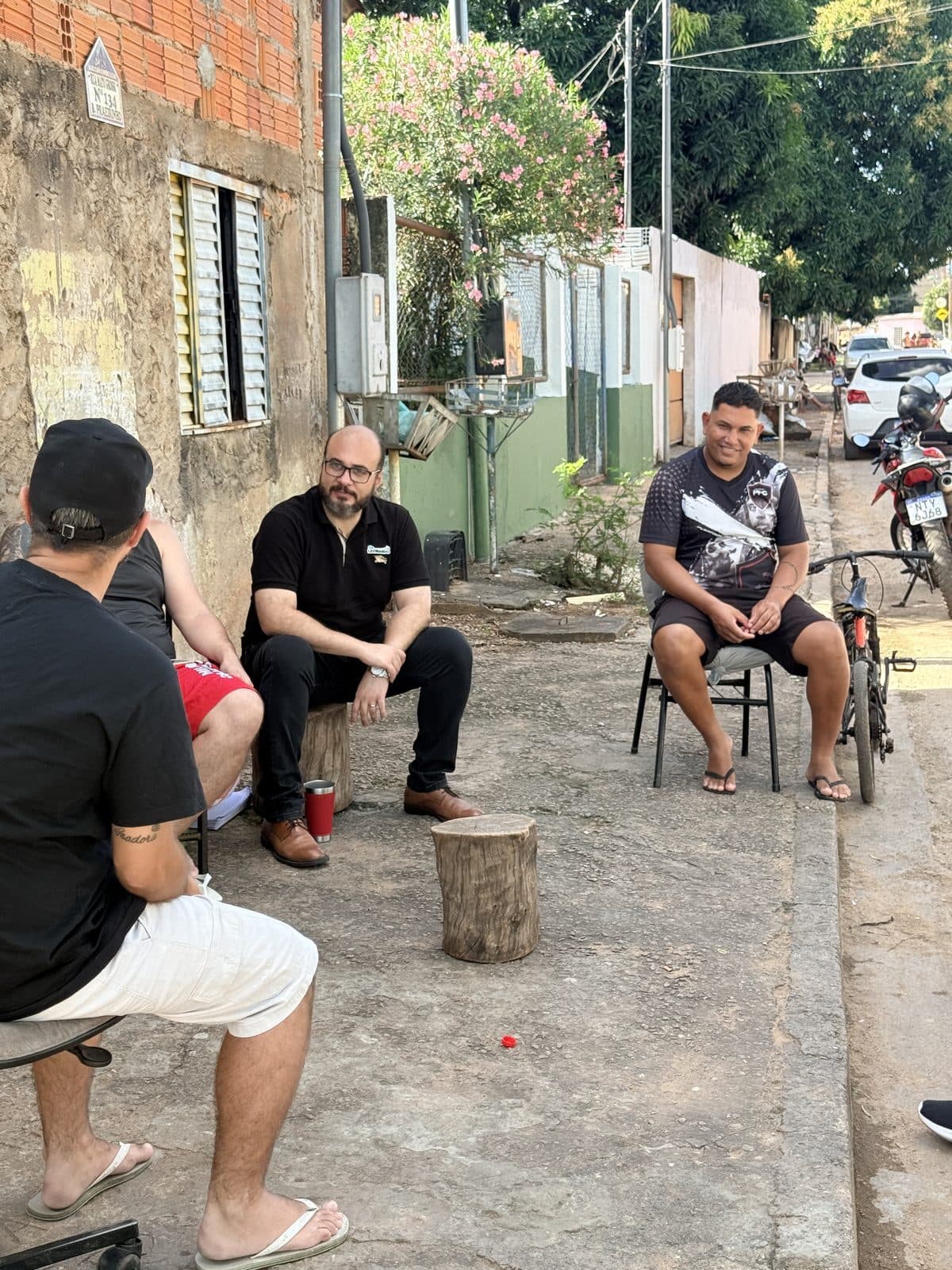 Dr. Leonardo sentado em roda de conversa com moradores, na rua do bairro Praeirinho
